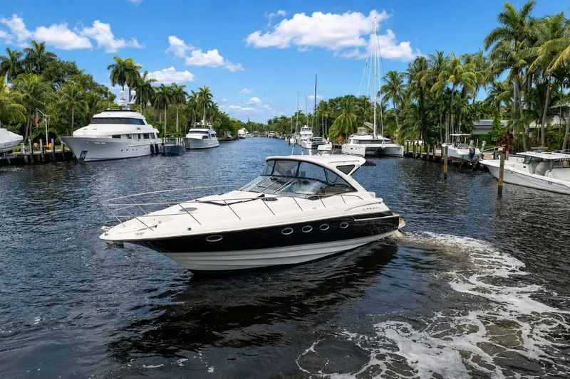 Slide: The Image of 2008 Regal Commodore 4460 yacht cruising in a scenic, palm-lined marina. - 6