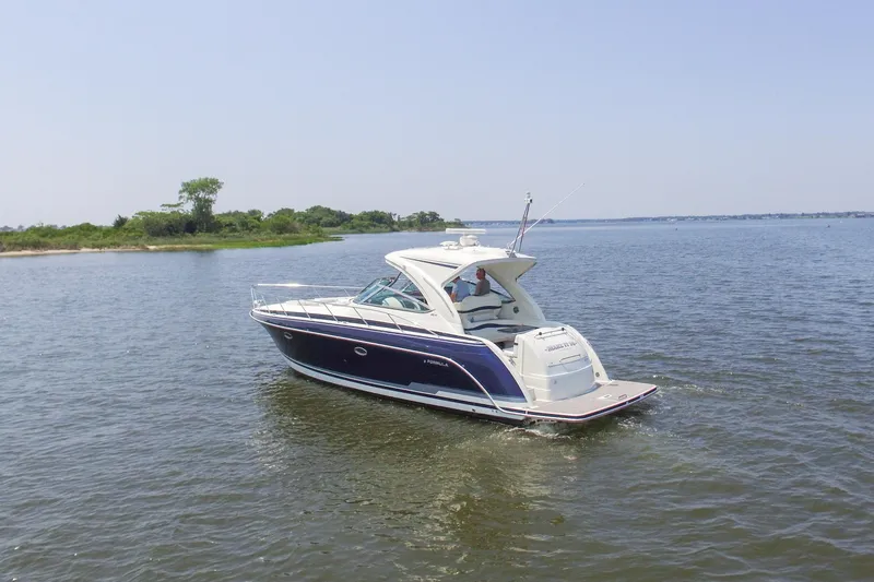 Slide: The Image of 2016 Formula 40 Performance Cruiser navigating calm waters near a lush shoreline. - 8