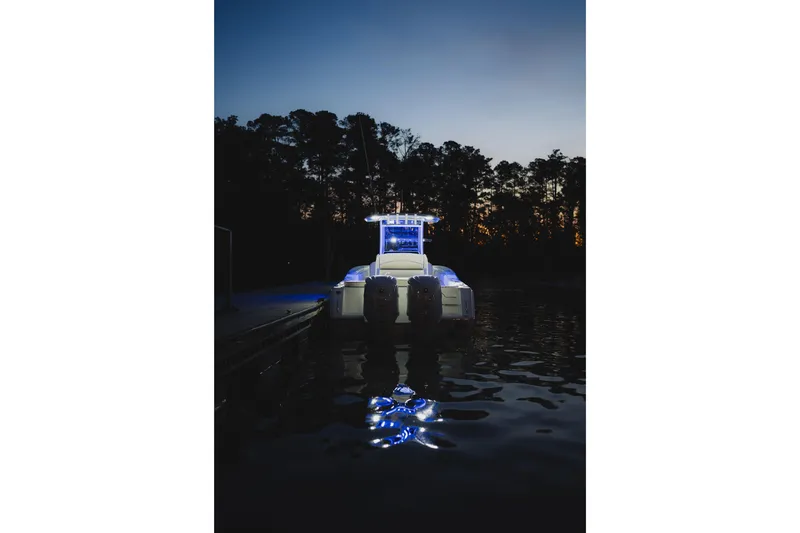 Slide: The Image of 2027 Sea Hunt Ultra 275 SE boat illuminated at dusk on calm water. - 5