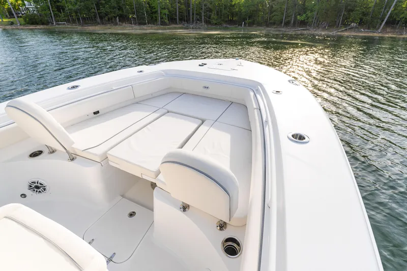 Slide: The Image of 2027 Sea Hunt Ultra 275 SE boat interior with cushioned seating on calm water. - 12