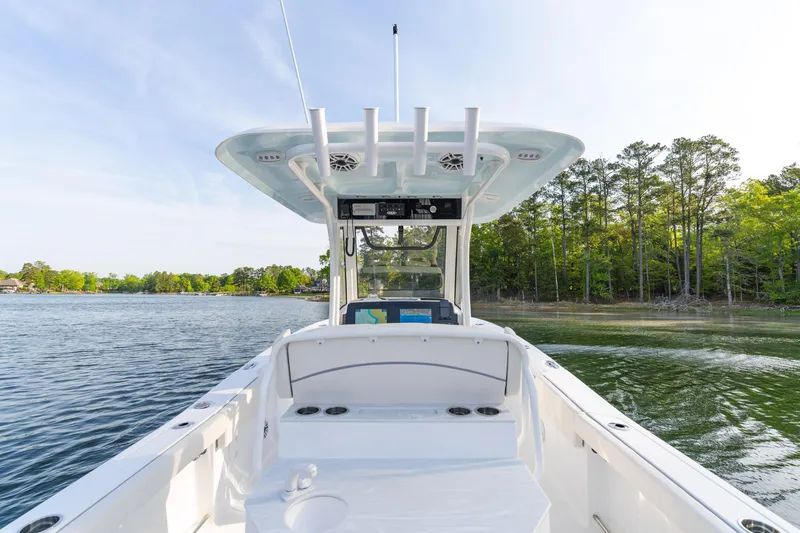 Slide: The Image of Sea Hunt Ultra 275 SE boat on a serene lake, surrounded by lush trees, 2027 model. - 15