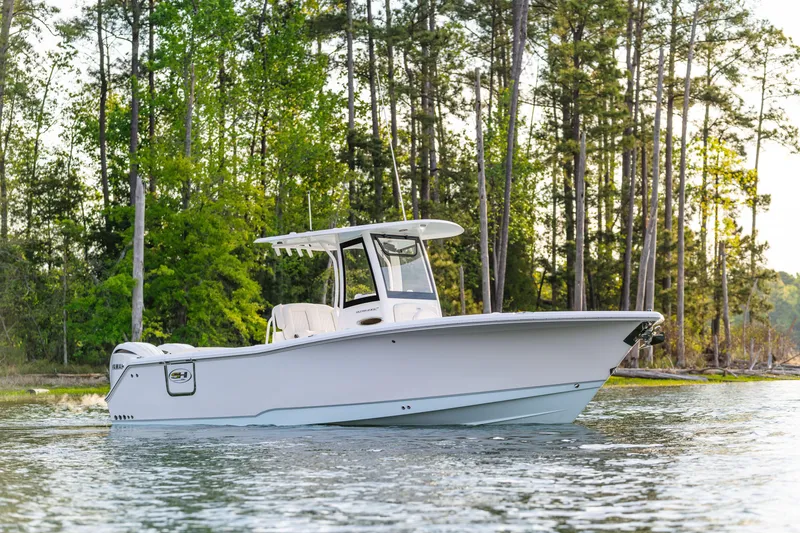 Slide: The Image of 2027 Sea Hunt Ultra 275 SE boat on a serene lake with forest backdrop. - 10