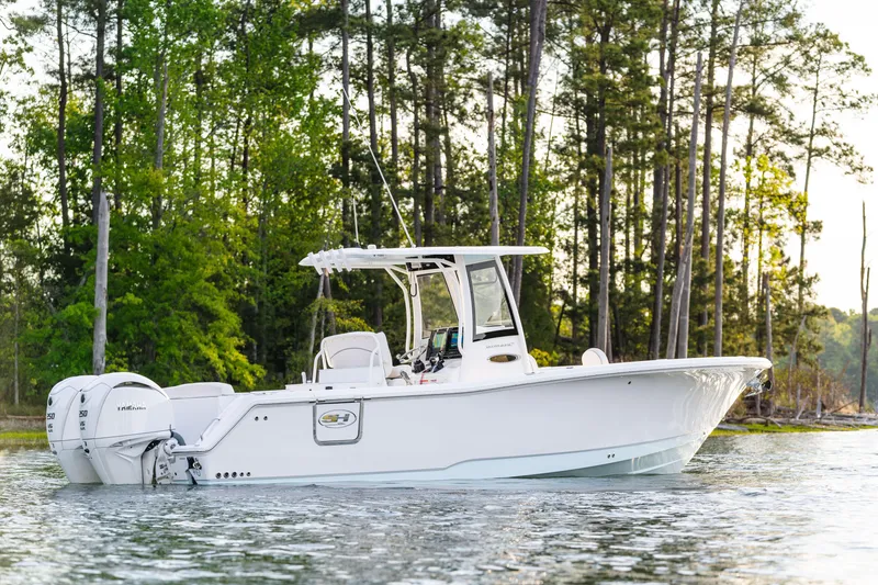 Slide: The Image of 2027 Sea Hunt Ultra 275 SE boat on a serene lake with forest backdrop. - 9