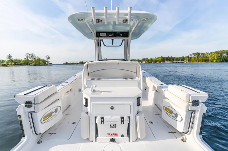 Slide: The Image of 2027 Sea Hunt Ultra 275 SE boat on calm water, showcasing spacious deck and seating. - 20