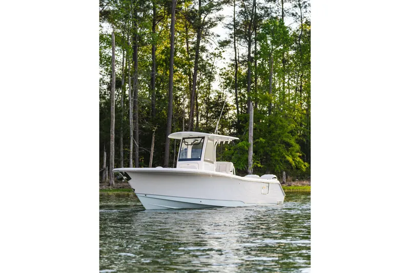 The Image of 2027 Sea Hunt Ultra 275 SE boat on calm water, surrounded by trees. - 7