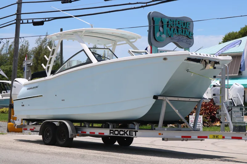 Slide: The Image of 2026 World Cat 280 DC-X boat on trailer at Unique Marine dealership. - 2