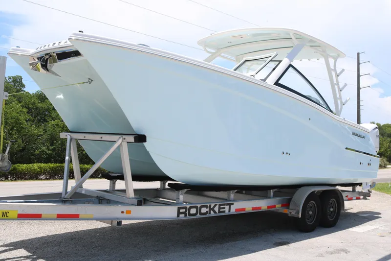 Slide: The Image of 2026 World Cat 280 DC-X boat on trailer, parked outdoors. - 1
