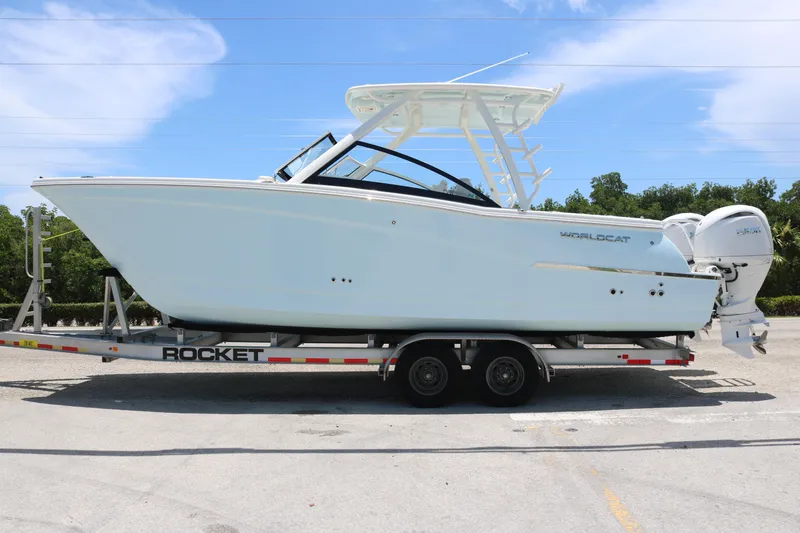 The Image of 2026 World Cat 280 DC-X boat on trailer, side view, clear sky background. - 0