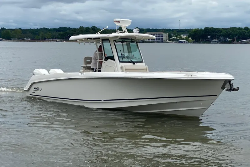 The Image of 2016 Boston Whaler 330 Outrage boat cruising on a calm lake. - 1