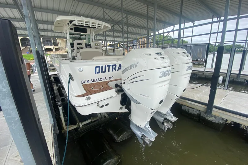Slide: The Image of 2016 Boston Whaler 330 Outrage with twin Mercury 350 engines docked in covered marina. - 10