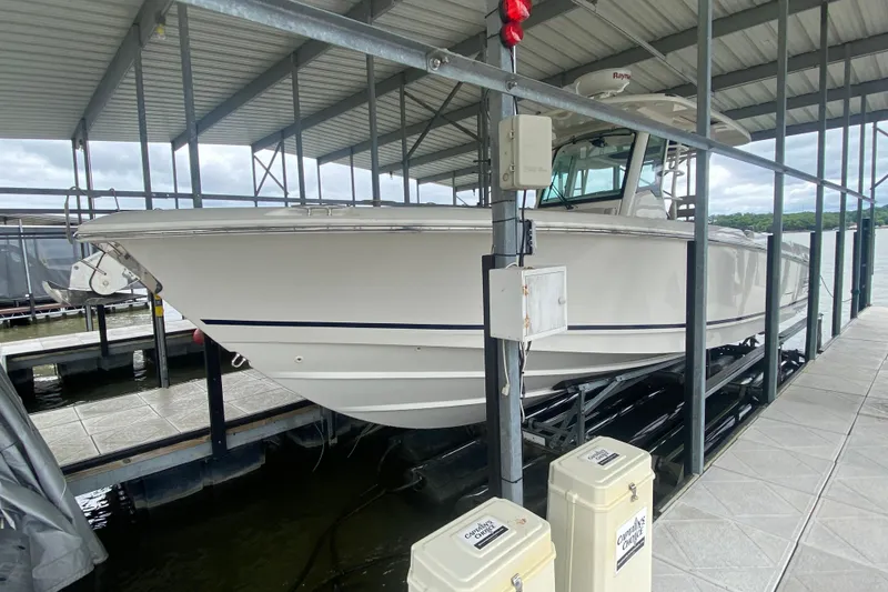 Slide: The Image of 2016 Boston Whaler 330 Outrage boat docked in a covered marina. - 11