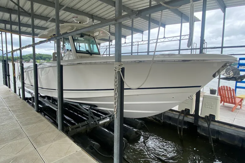 Slide: The Image of 2016 Boston Whaler 330 Outrage boat docked in a covered marina. - 12