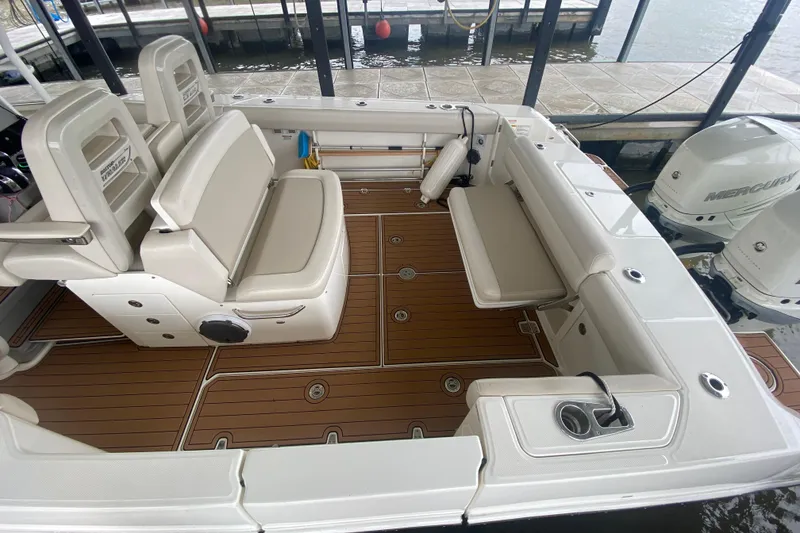 Slide: The Image of 2016 Boston Whaler 330 Outrage boat interior with cushioned seating and teak flooring. - 14