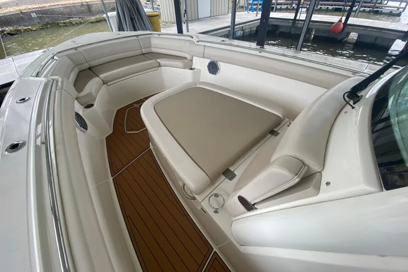 Slide: The Image of 2016 Boston Whaler 330 Outrage boat interior with cushioned seating and teak flooring. - 23