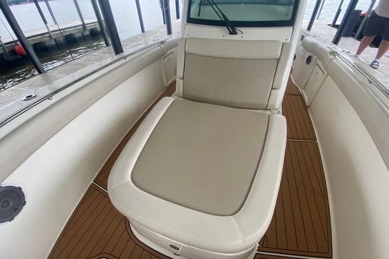 Slide: The Image of 2016 Boston Whaler 330 Outrage boat interior with cushioned seating and teak flooring. - 24