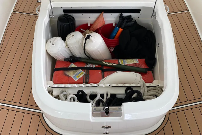 Slide: The Image of Storage compartment on a 2016 Boston Whaler 330 Outrage, filled with boating gear. - 25