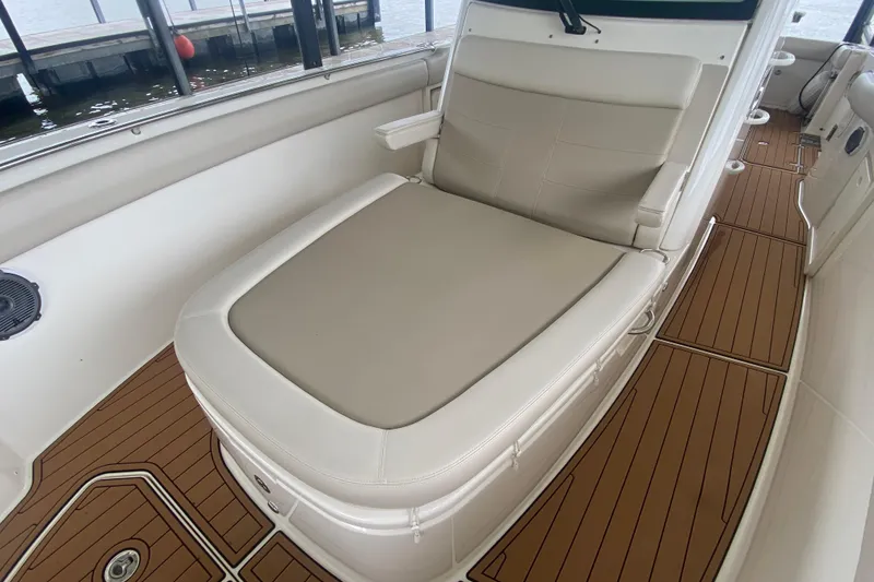 Slide: The Image of 2016 Boston Whaler 330 Outrage boat interior with cushioned seating and teak flooring. - 26