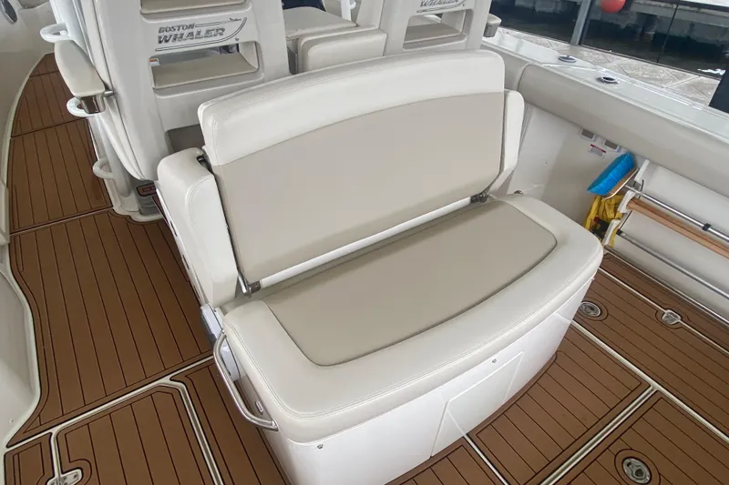 Slide: The Image of 2016 Boston Whaler 330 Outrage interior with cushioned seating and teak-style flooring. - 28