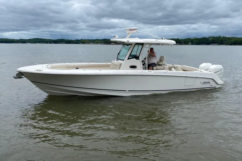 Slide: The Image of 2016 Boston Whaler 330 Outrage boat on calm water under cloudy sky. - 3