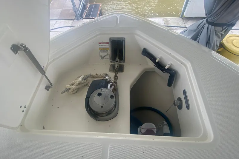 Slide: The Image of Anchor storage compartment on a 2016 Boston Whaler 330 Outrage boat, featuring rope and equipment. - 32