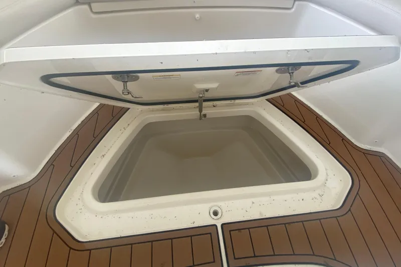 Slide: The Image of Open storage compartment on 2016 Boston Whaler 330 Outrage boat with teak flooring. - 33