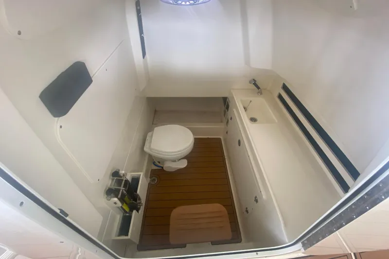Slide: The Image of Interior of 2016 Boston Whaler 330 Outrage boat bathroom with toilet and sink. - 35