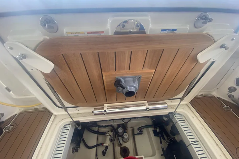 Slide: The Image of Boston Whaler 330 Outrage 2016 boat hatch with wooden cover and mechanical components. - 41