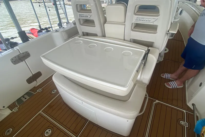 Slide: The Image of Boston Whaler 330 Outrage 2016 boat interior with seating and table setup. - 43