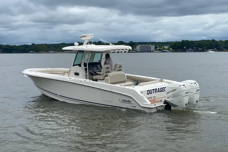 Slide: The Image of 2016 Boston Whaler 330 Outrage boat on a calm lake under cloudy skies. - 5