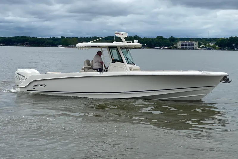 Slide: The Image of 2016 Boston Whaler 330 Outrage boat cruising on a calm lake under cloudy skies. - 6