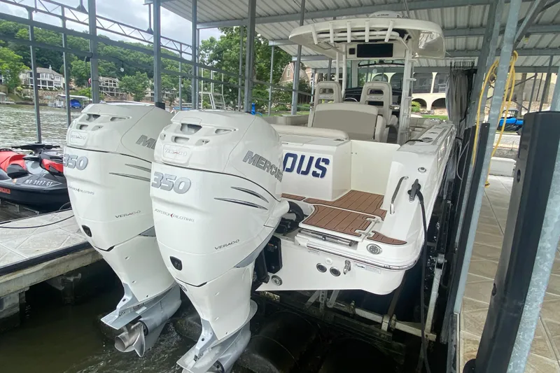 Slide: The Image of 2016 Boston Whaler 330 Outrage with twin Mercury 350 engines docked under a canopy. - 7