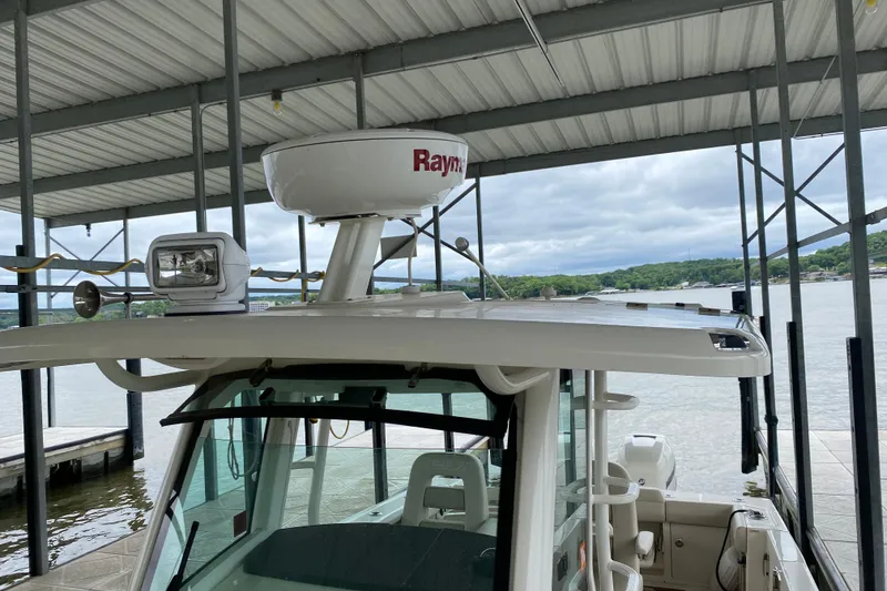 Slide: The Image of 2016 Boston Whaler 330 Outrage docked under a covered marina with radar equipment. - 9