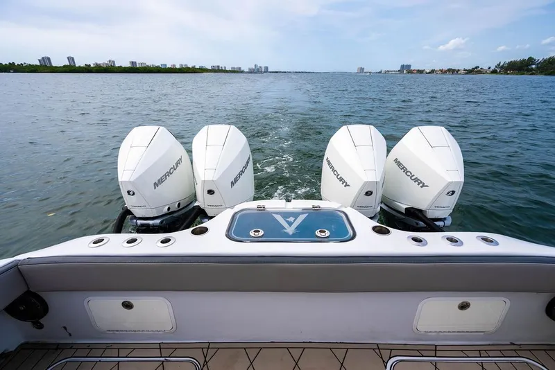Slide: The Image of Four outboard engines on a boat in calm waters. - 10