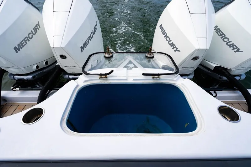 Slide: The Image of Rear view of a boat with four Mercury engines and a blue storage compartment. - 13