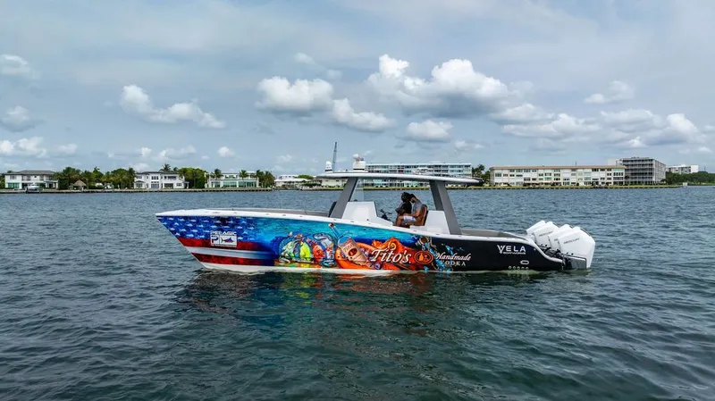 Slide: The Image of A 2021 Custom 368 Center Console boat on the water with striking graphics. - 2