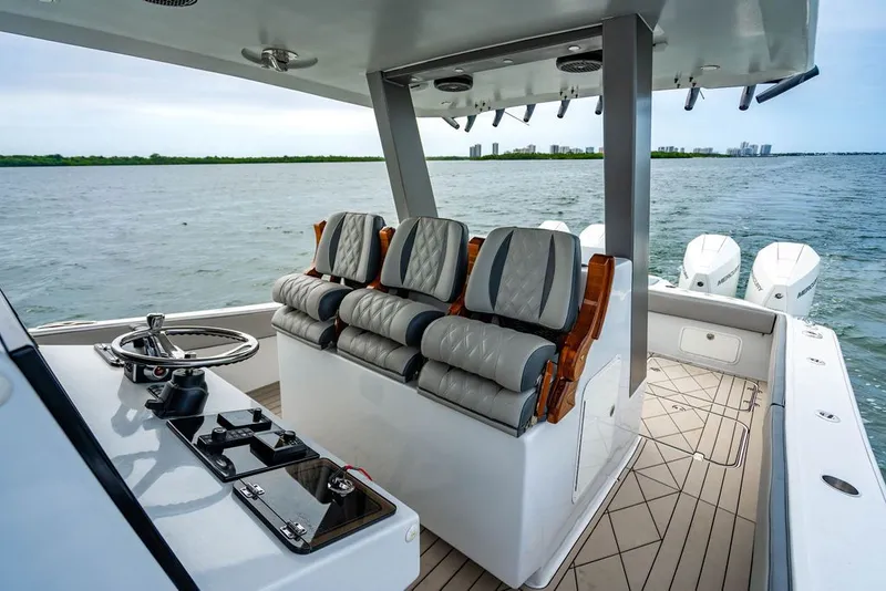 Slide: The Image of Interior view of a modern boat with three cushioned seats and a steering console. - 25