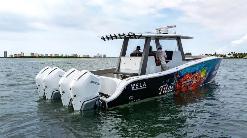 Slide: The Image of A 2021 Custom 368 Center Console boat with striking side artwork and four outboard engines. - 6