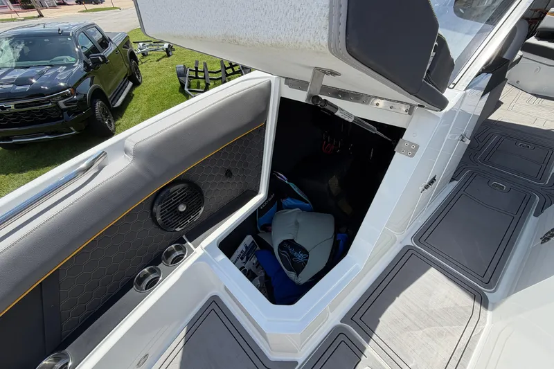Slide: The Image of 2021 Cobalt R8 Surf boat interior storage compartment with open hatch and visible gear. - 13