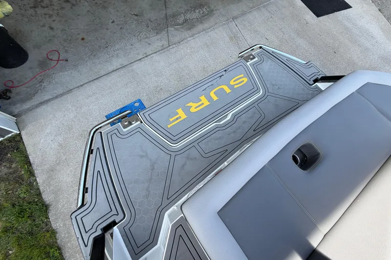 Slide: The Image of 2021 Cobalt R8 Surf boat platform with "SURF" logo, gray upholstery, and concrete background. - 21