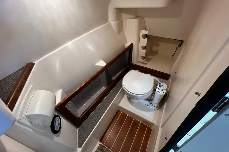 Slide: The Image of 2014 Grady-White Freedom 275 boat bathroom with toilet and wooden flooring. - 10