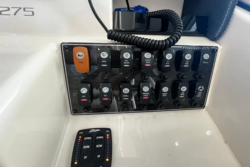Slide: The Image of Control panel of a 2014 Grady-White Freedom 275 boat with various switches and buttons. - 15