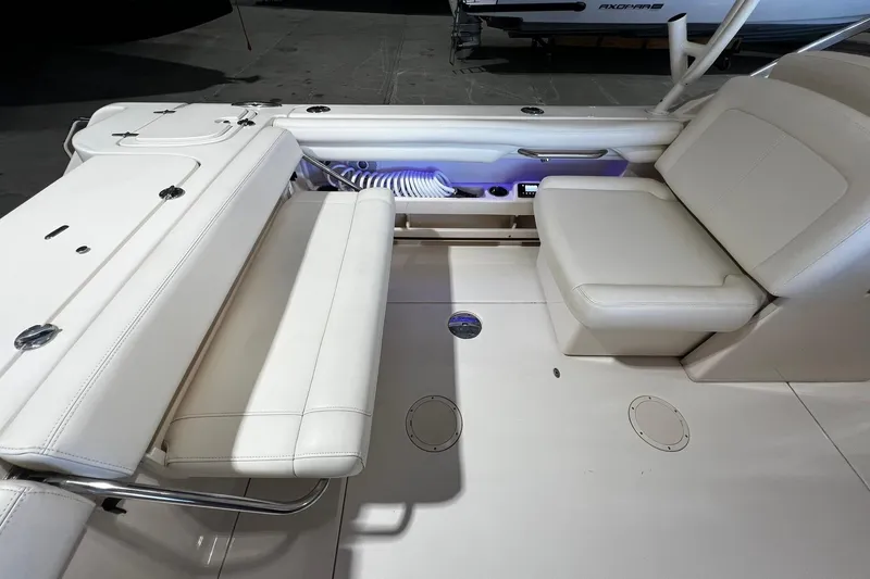 Slide: The Image of 2014 Grady-White Freedom 275 boat interior with white seating and storage compartments. - 22