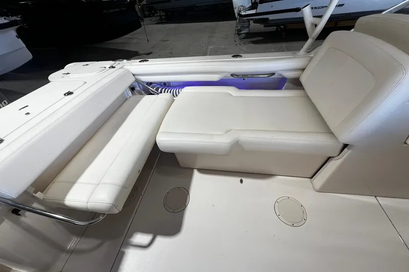 Slide: The Image of 2014 Grady-White Freedom 275 boat interior with white seating and storage compartments. - 23