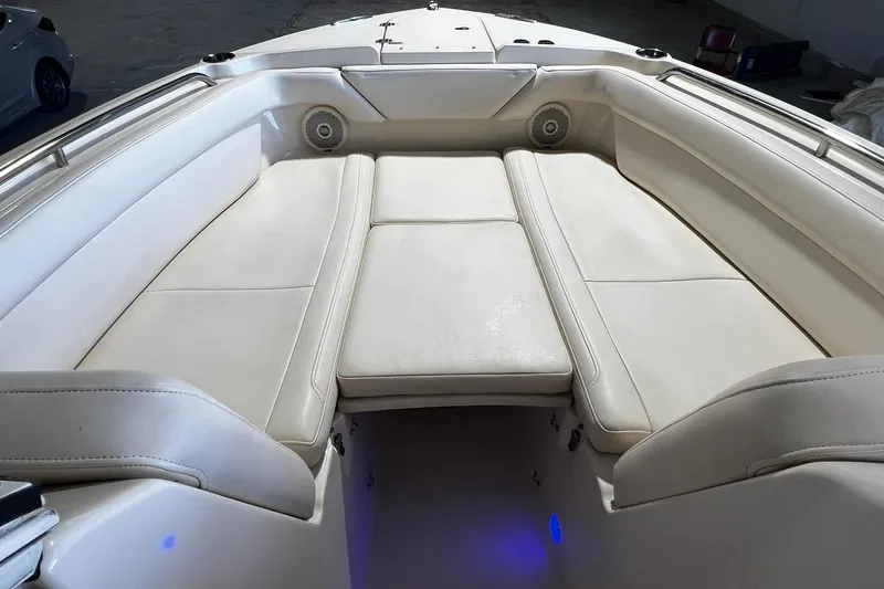 Slide: The Image of 2014 Grady-White Freedom 275 boat interior with cushioned seating and built-in speakers. - 8