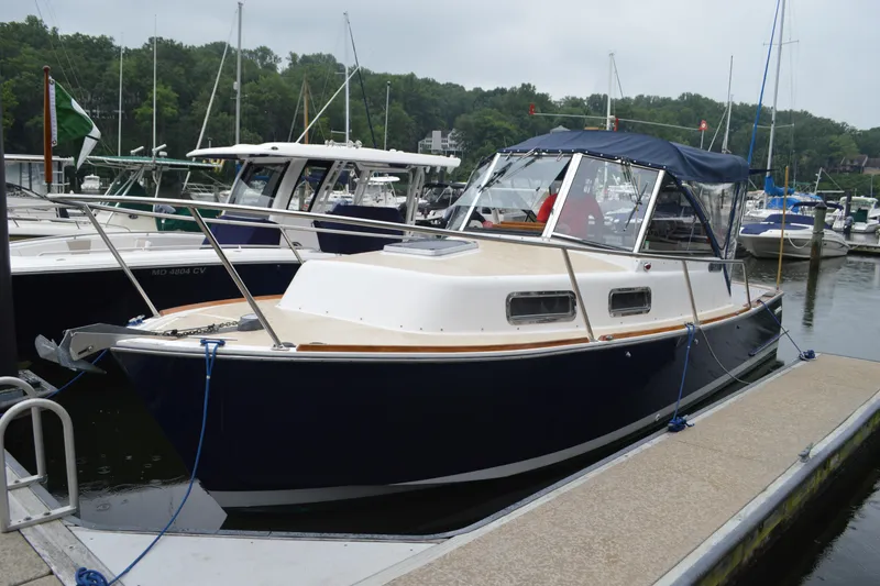 Slide: The Image of 2003 Legacy 28 Express boat docked at marina, featuring sleek design and blue hull. - 1