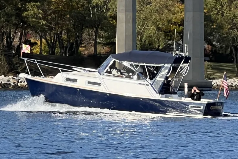 The Image of 2003 Legacy 28 Express boat cruising on a sunny day near a bridge. - 0