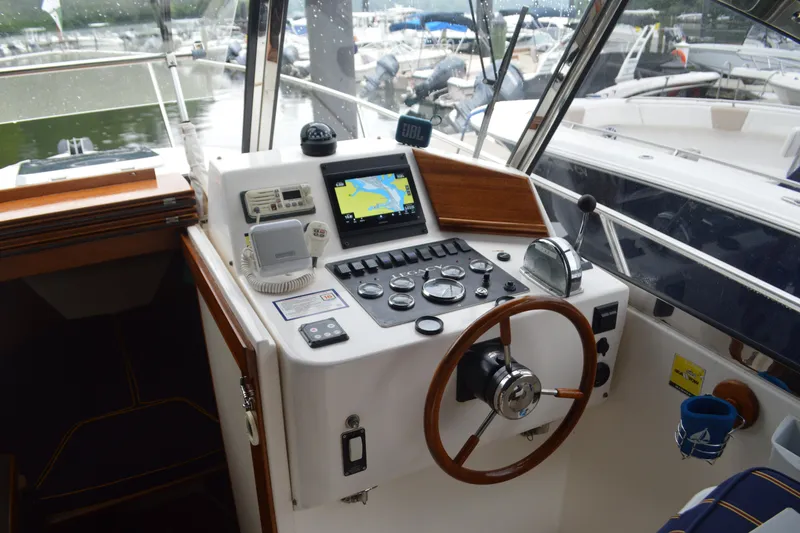 Slide: The Image of Helm of 2003 Legacy 28 Express boat with navigation equipment and wooden steering wheel. - 5