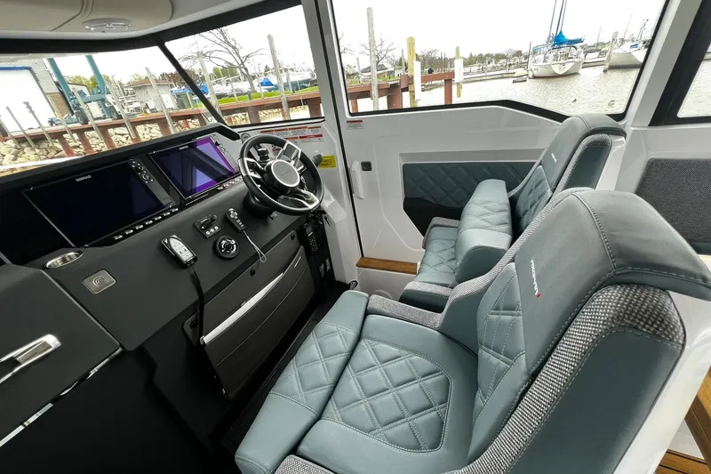 Slide: The Image of 2025 Axopar 37 XC Cross Cabin interior with modern dashboard and luxurious seating. - 12
