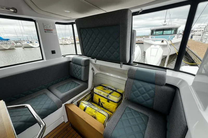 Slide: The Image of Interior of 2025 Axopar 37 XC Cross Cabin with seating and life jackets. - 16