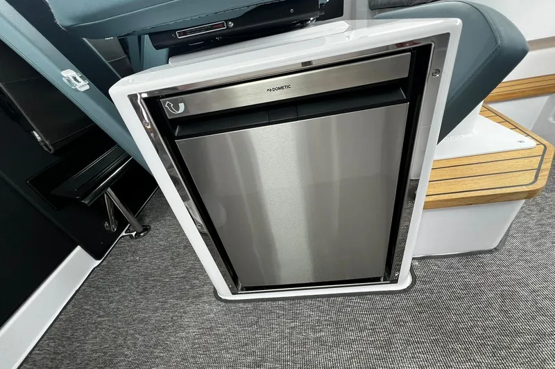 Slide: The Image of 2025 Axopar 37 XC Cross Cabin interior with compact stainless steel refrigerator. - 17
